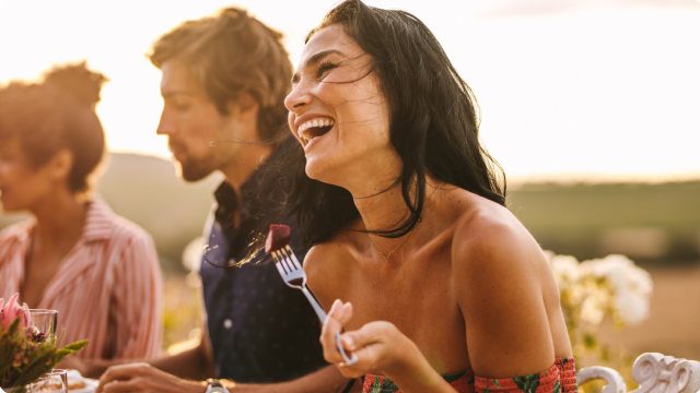 Smiling woman dining outdoors